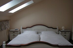 Ein Standard-Hotelzimmer mit einem Einzelbett, zwei Nachttischen und einem Oberlicht.