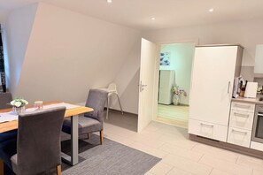 Een moderne keuken met witte kastjes en een inbouwoven.
