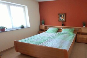 A bedroom with a bed, a window, and a wall-mounted picture. - ||-----------------------Erdener Steps----------------------|| (Erden)