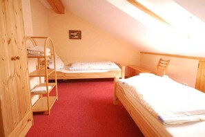 A small, cozy room with a sloped ceiling, a bunk bed, a wooden wardrobe, and a single bed. - Heller Holiday Winery (Traben-Trarbach \/ Wolf)