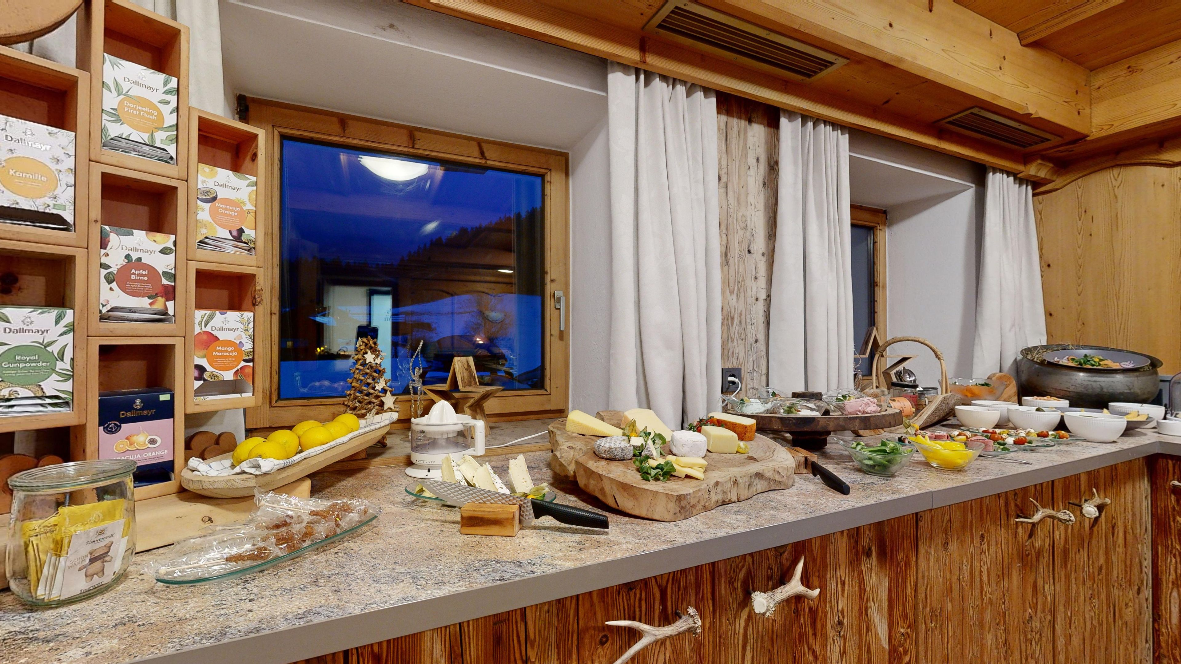 Eine Küche mit Holzregalen, einem großen Fenster und verschiedenen Lebensmitteln auf der Arbeitsfläche.