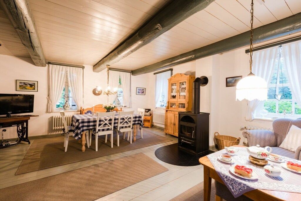 Uma sala de estar acolhedora com lareira, espaço de refeições e televisão.