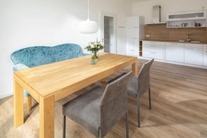 A modern kitchen with white cabinets and a wooden countertop. - Holiday apartment in Juist with swimming pool (Juist)