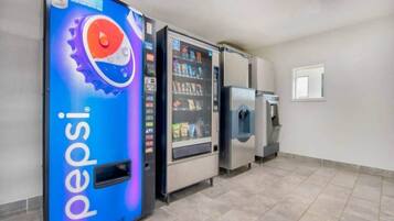 Automat med Pepsi-branding, en vanddispenser og et køleskab i en gang.