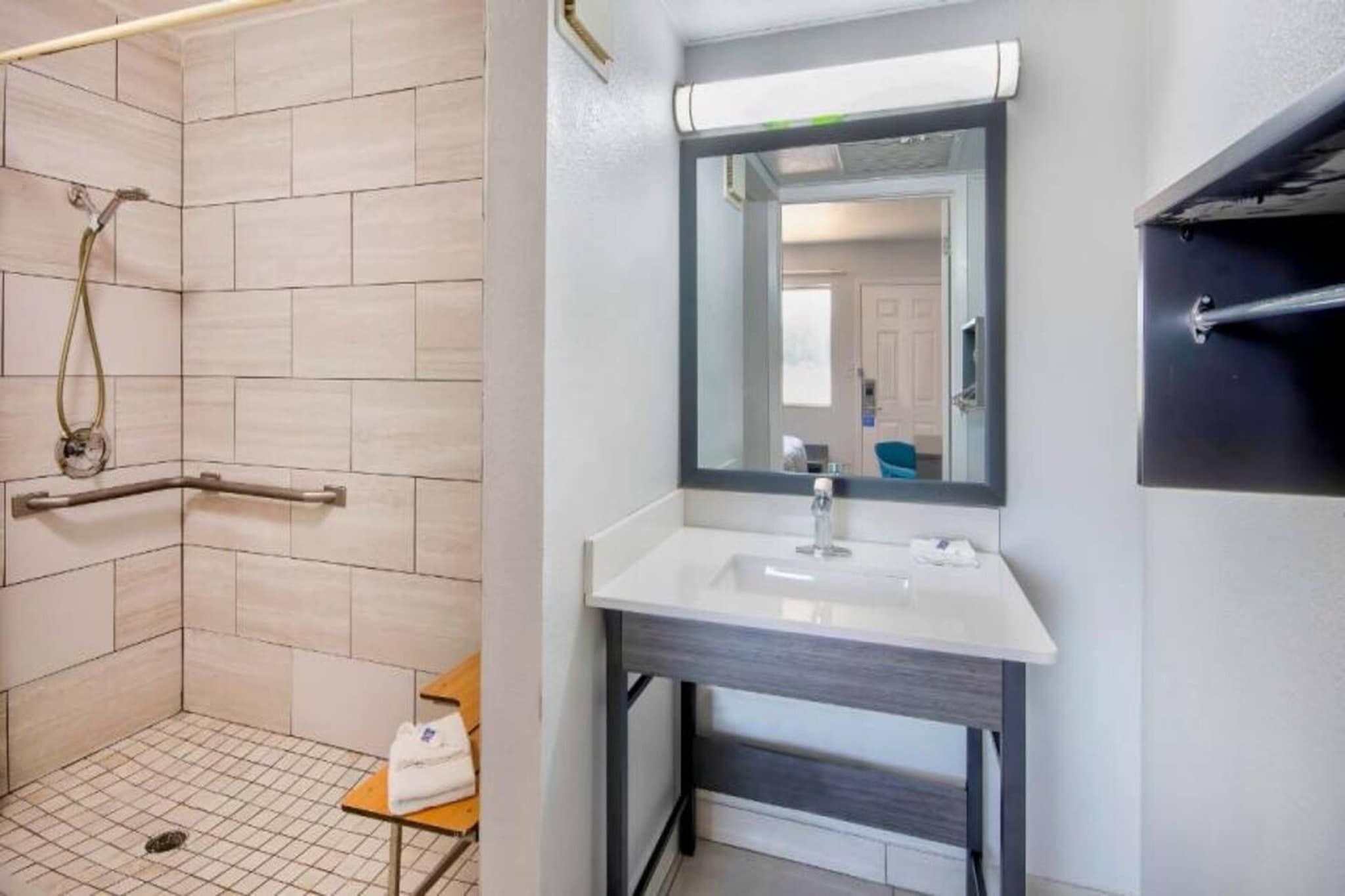 Une salle de bain avec une douche, un lavabo et un miroir.