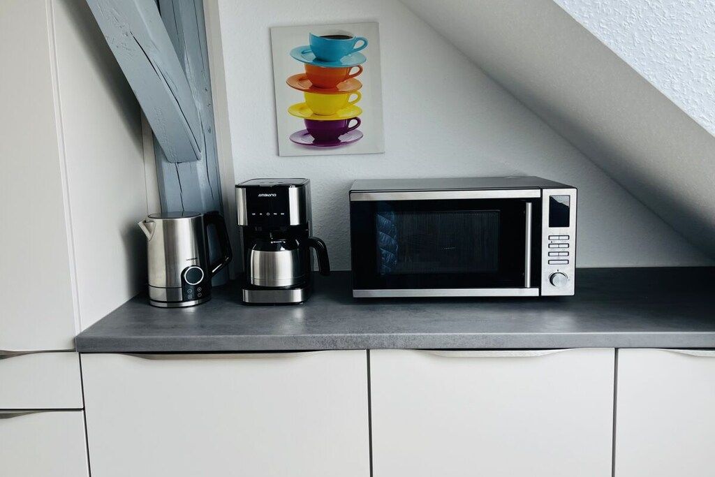 Eine Küchenarbeitsplatte mit Kaffeemaschine und Mikrowelle.