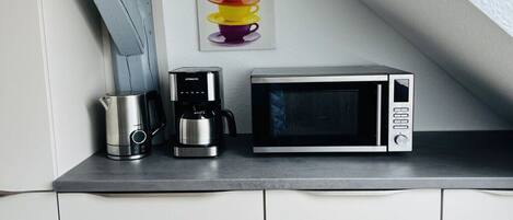 Eine Küchenarbeitsplatte mit Kaffeemaschine und Mikrowelle.