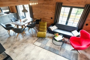 Ein modernes Interieur mit Essbereich, Sofa und einem roten Sessel.