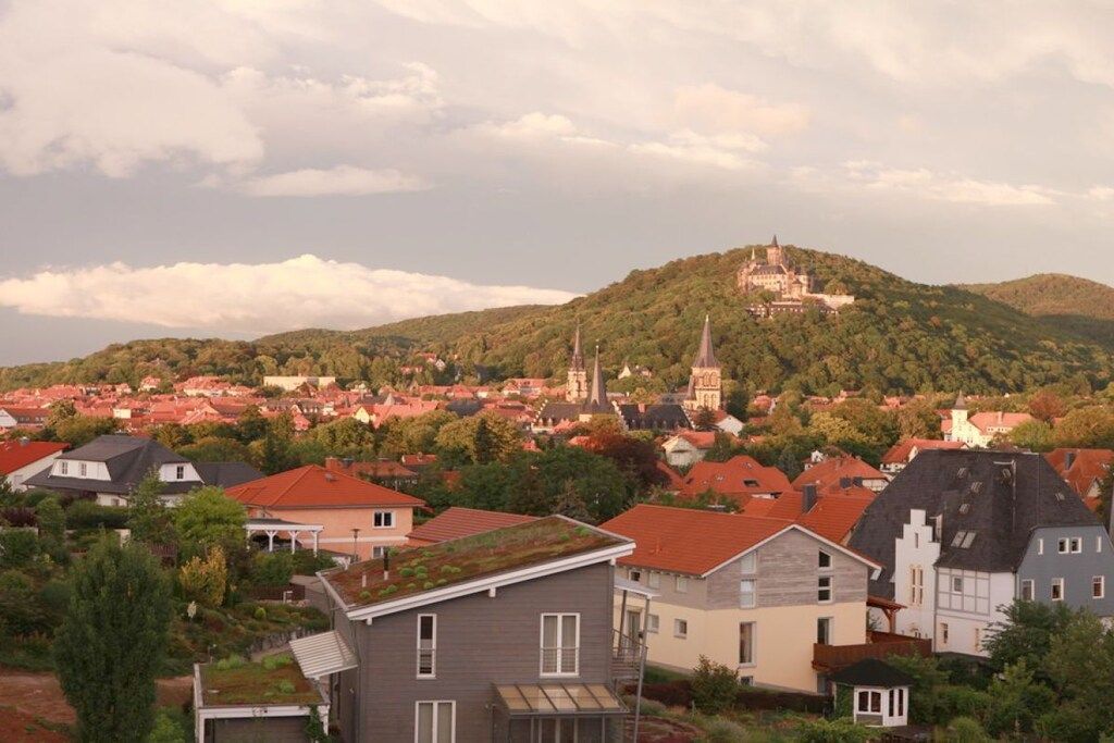 A residential area with houses, a church, and a castle on a hill.