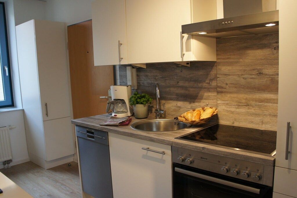 A modern kitchen with a built-in stove, a sink, and a dishwasher.