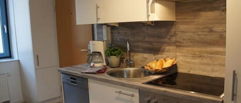 Una cocina moderna con estufa integrada, un fregadero y lavavajillas.