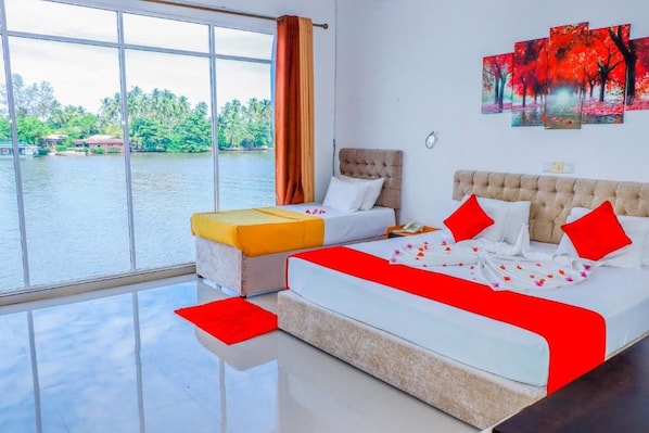 A hotel room with a large window, a bed, a sofa, and a painting on the wall.