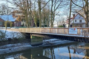 A wooden bridge over a river with a sign for Nordsee. - Holiday apartment with 1 bedroom (Butjadingen)