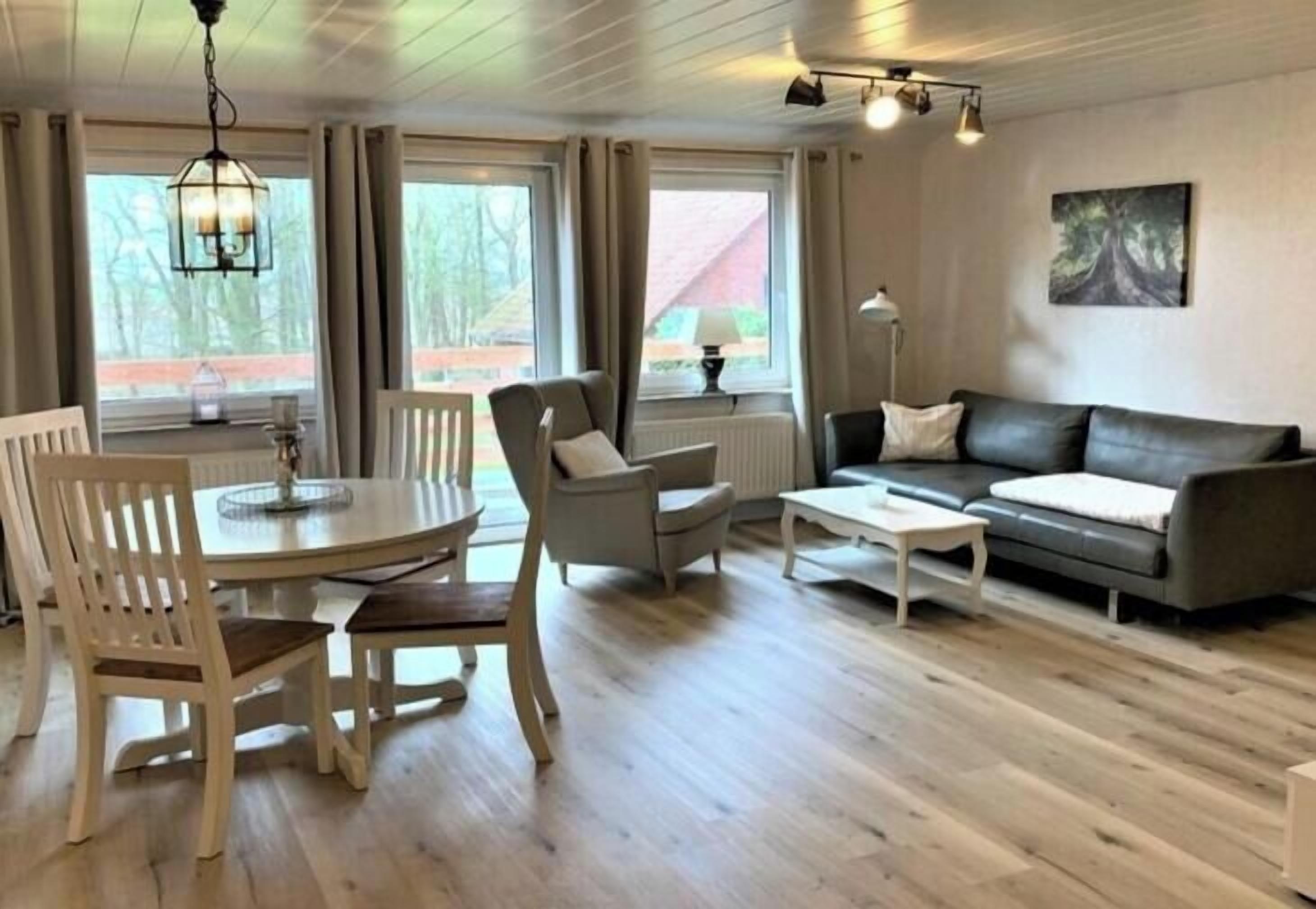 Ein Zimmer mit Esstisch, Stühlen, einer Couch und einem Couchtisch.