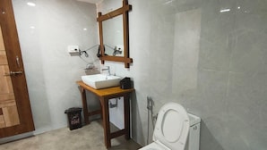 Casa de banho com sanita, lavatório e espelho.