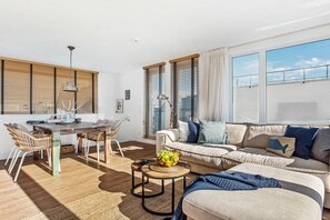 A modern living room with a sofa, dining table, and chairs. - Houseboat in Olpenitz with swimming pool (Olpenitz)