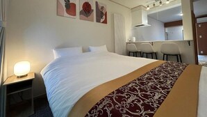 Ein Hotelzimmer mit einem großen Bett, einem Schreibtisch und einem Sessel.
