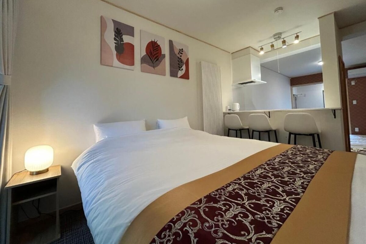Una habitación de hotel con una cama grande, un escritorio y una silla.