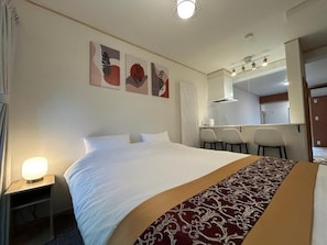Una habitación de hotel con una cama grande, un escritorio y una silla.