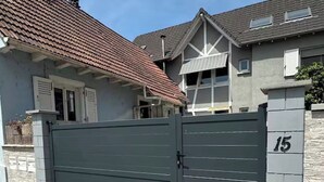Una propietat residencial amb tanca, carrer empedrat i el número 15 a la porta.