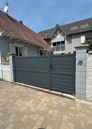 Ein geschlossenes Wohnanwesen mit befestigter Auffahrt und der Hausnummer 15 am Tor.