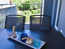 A balcony with two chairs, a table, and a tray with decorative items.