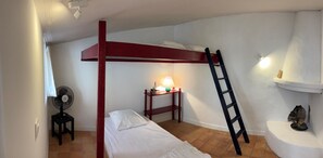 A bunk bed with a ladder, a bedside table with a lamp, and a small stool. - MARTINE'S HOUSE (La couarde sur mer)