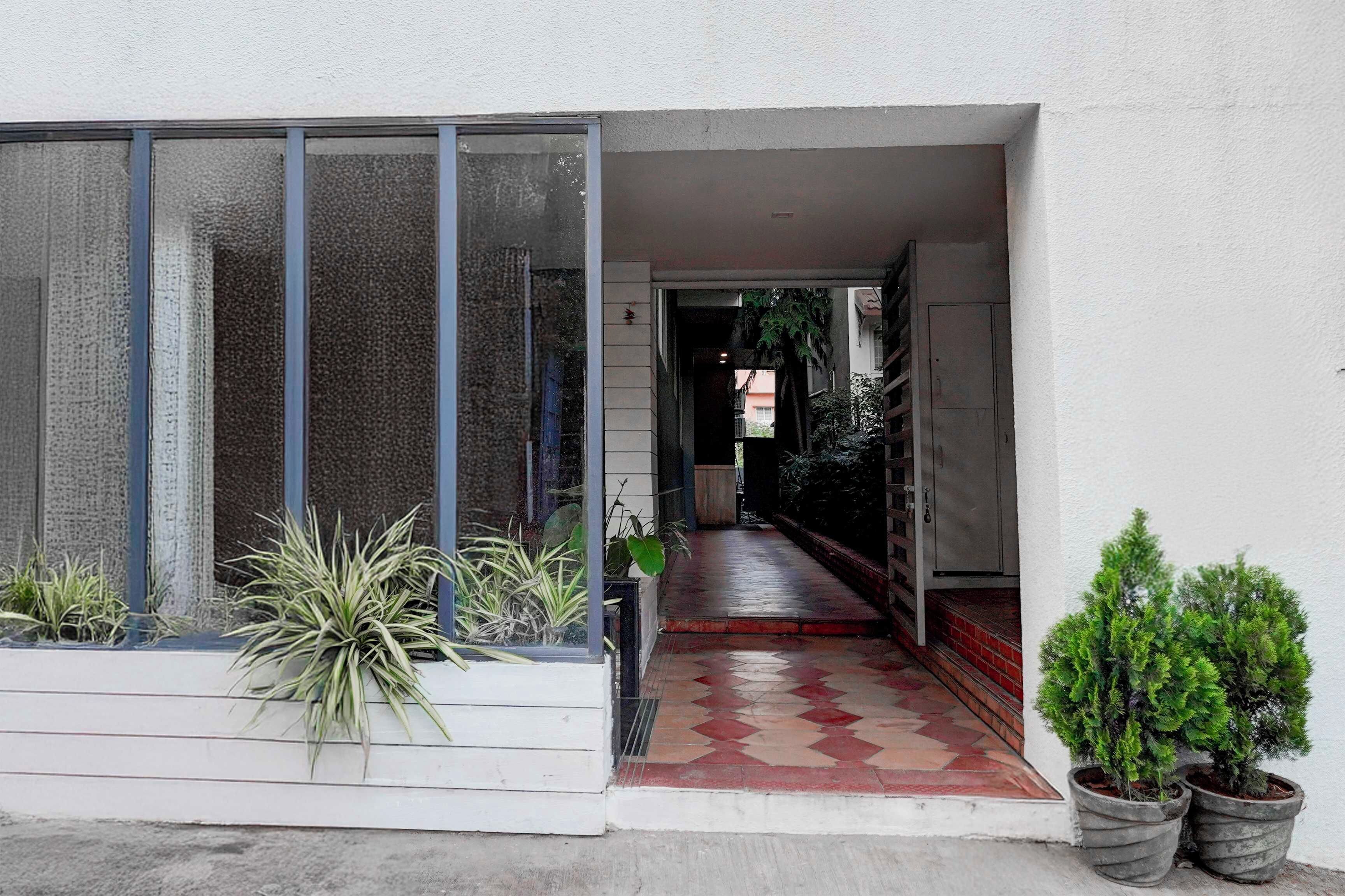 Uma entrada estreita com piso de azulejos que leva a um espaço coberto.