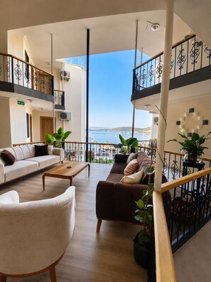 A spacious balcony with a view of the sea, furnished with a sofa, chairs, and a coffee table. - Deniz 61 Otel (Bodrum)