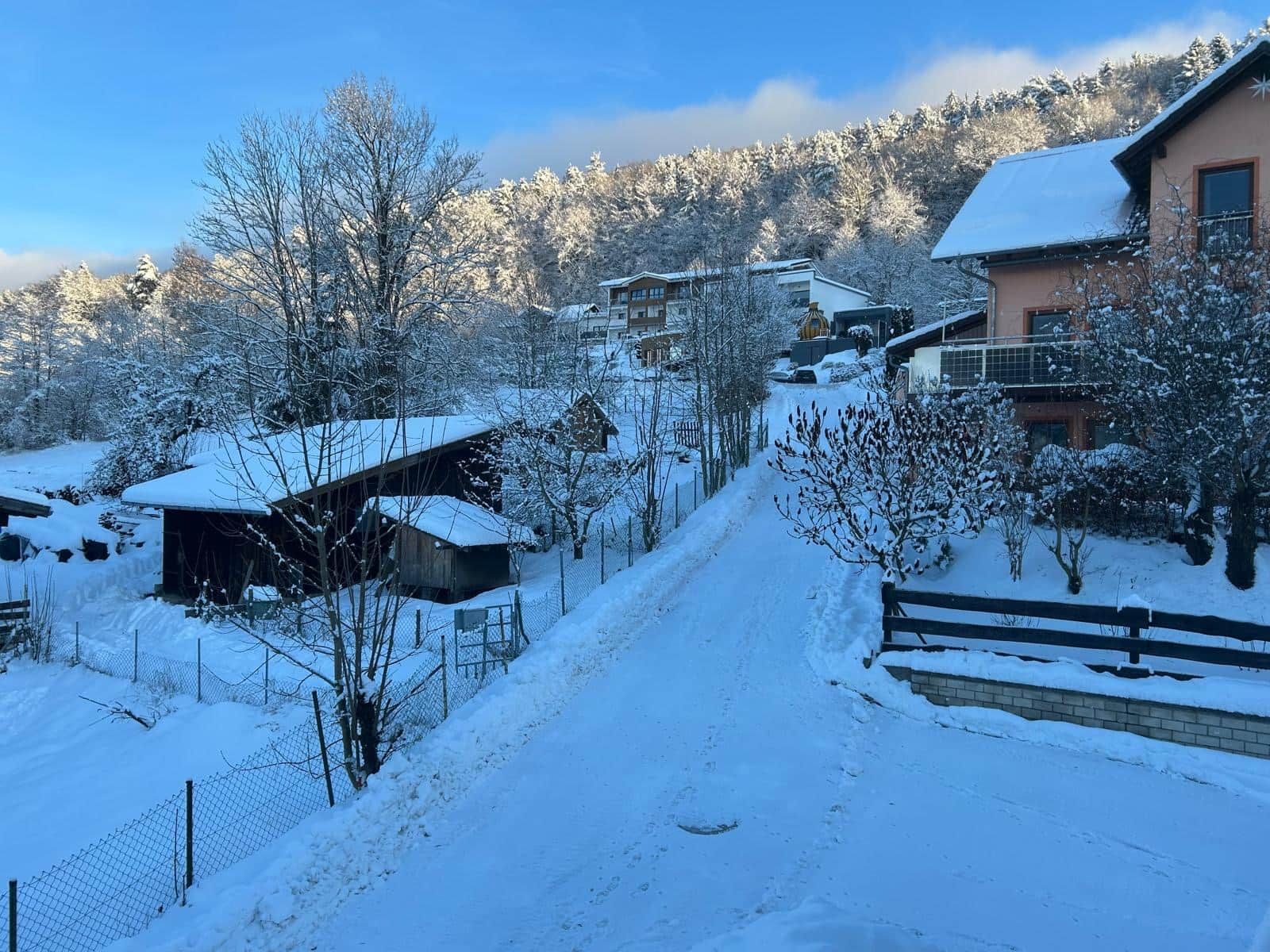 A snow-covered village with buildings and a clear sky.