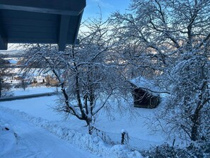 Un paisaje nevado con una casa y árboles.