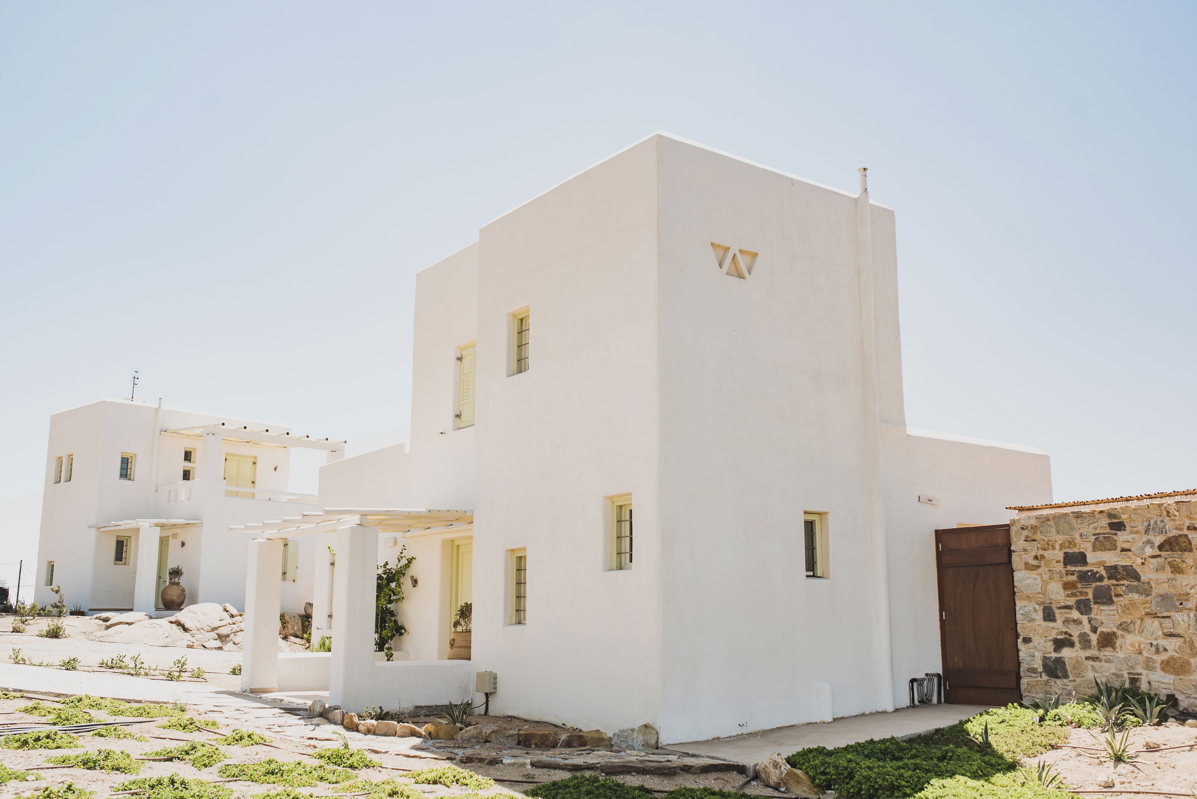 Un edificio blanco con varias ventanas y una pared de piedra.