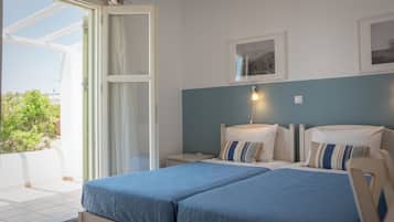 A bedroom with a bed, bedside tables, a nightstand, a window, and a wall-mounted picture.