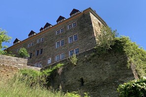 Ein mehrstöckiges Gebäude aus Stein mit flachem Dach und mehreren Fenstern.