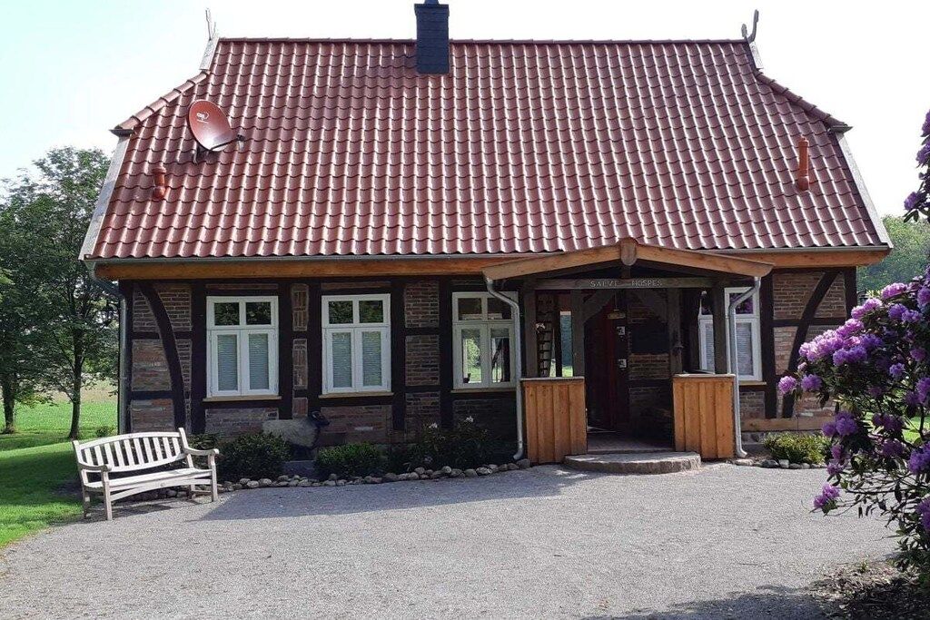 A traditional building with a tiled roof, a front porch, and a bench outside.