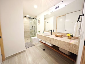 A modern bathroom with a glass shower enclosure, a large mirror, and a marble countertop. - Leonora 3 · 180 m² steps from Masaryk and Antara · 4 baths (Ciudad de México)