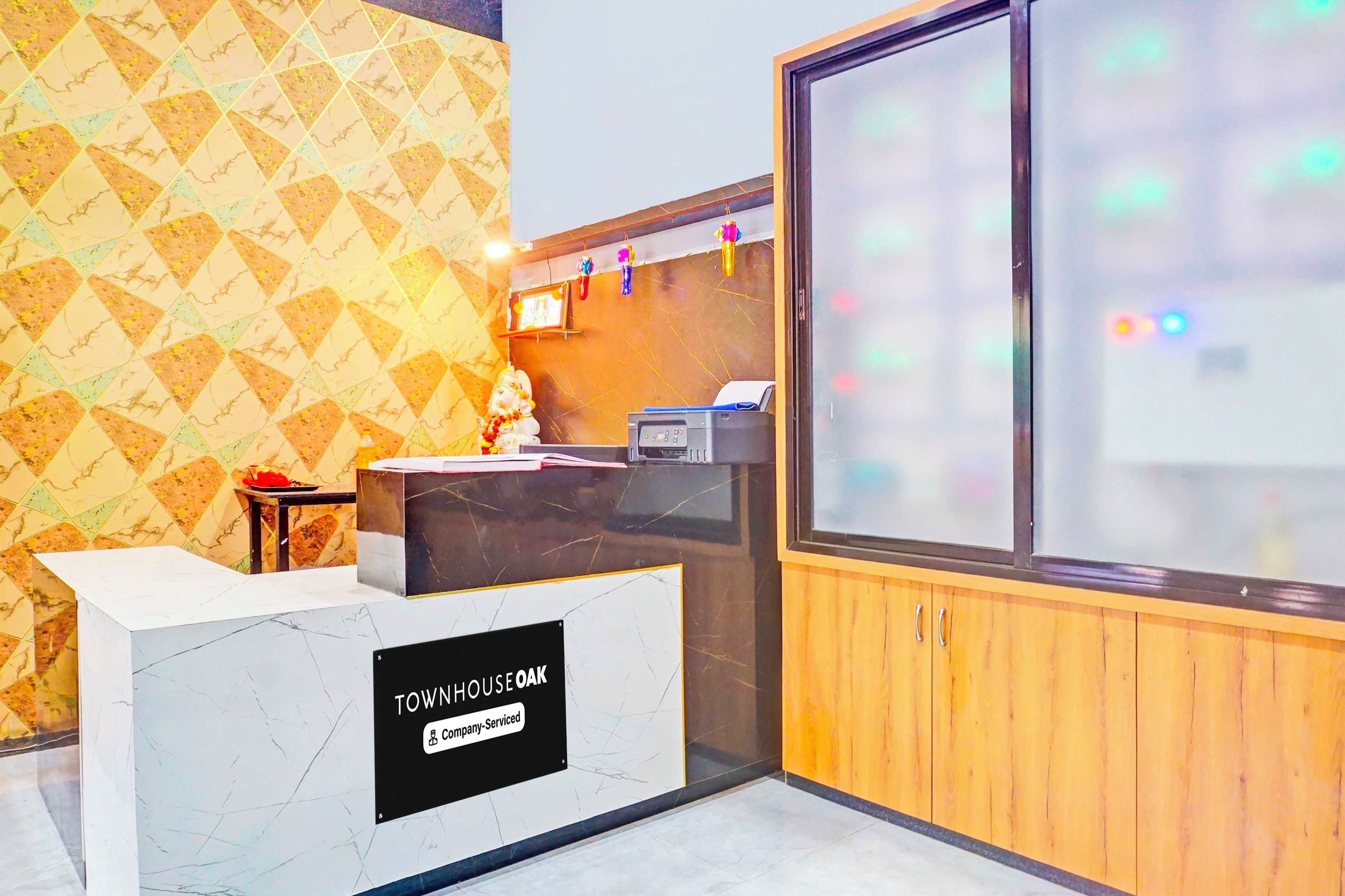 A reception desk with a marble top, a wooden paneling wall, and a patterned wallpaper.