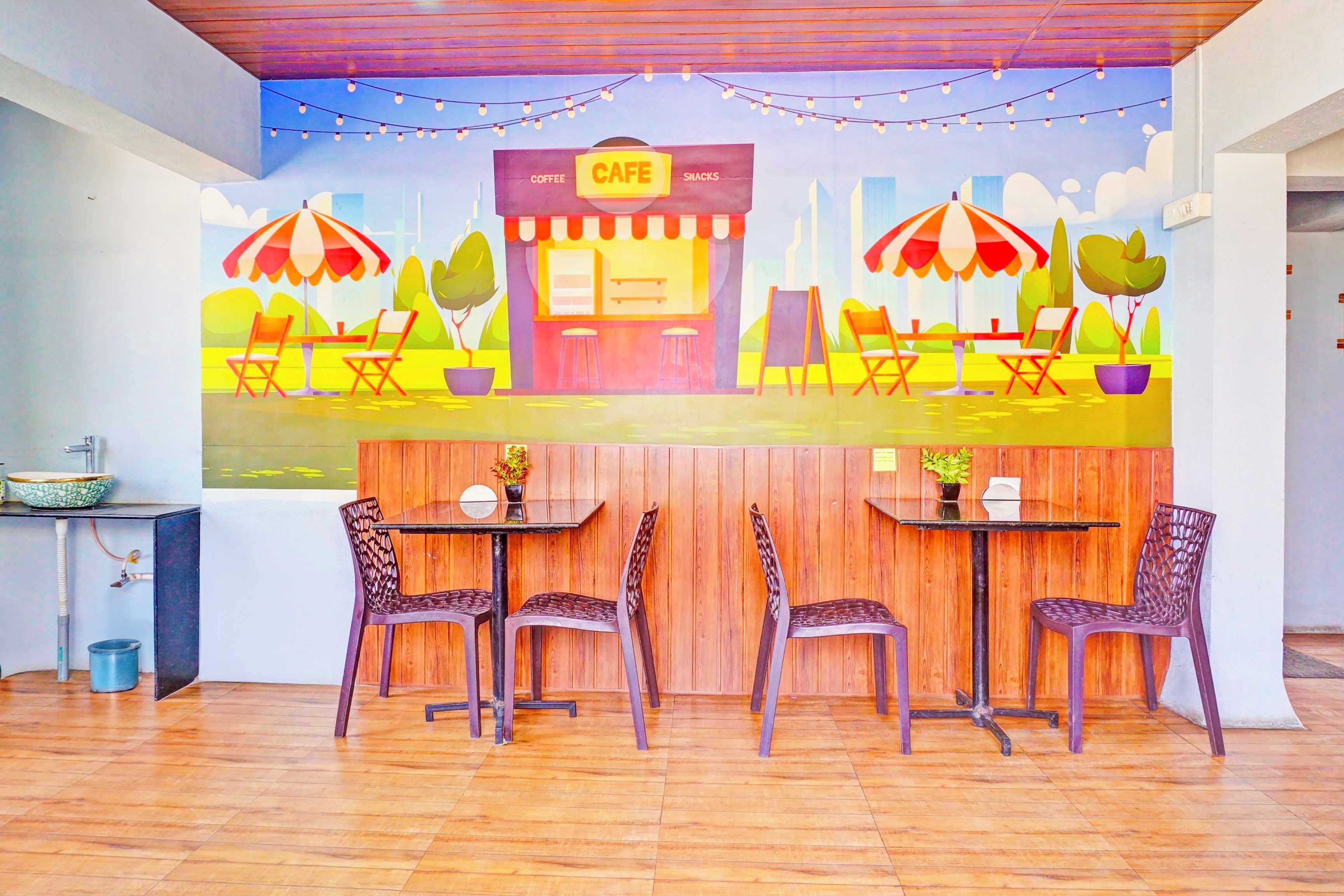 Una cafetería con terraza, suelo de madera y un mural en la pared.