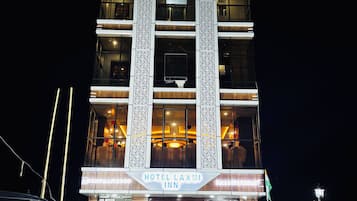 A multi-story hotel with a prominent sign reading 'HOTEL LAXMI INN.'