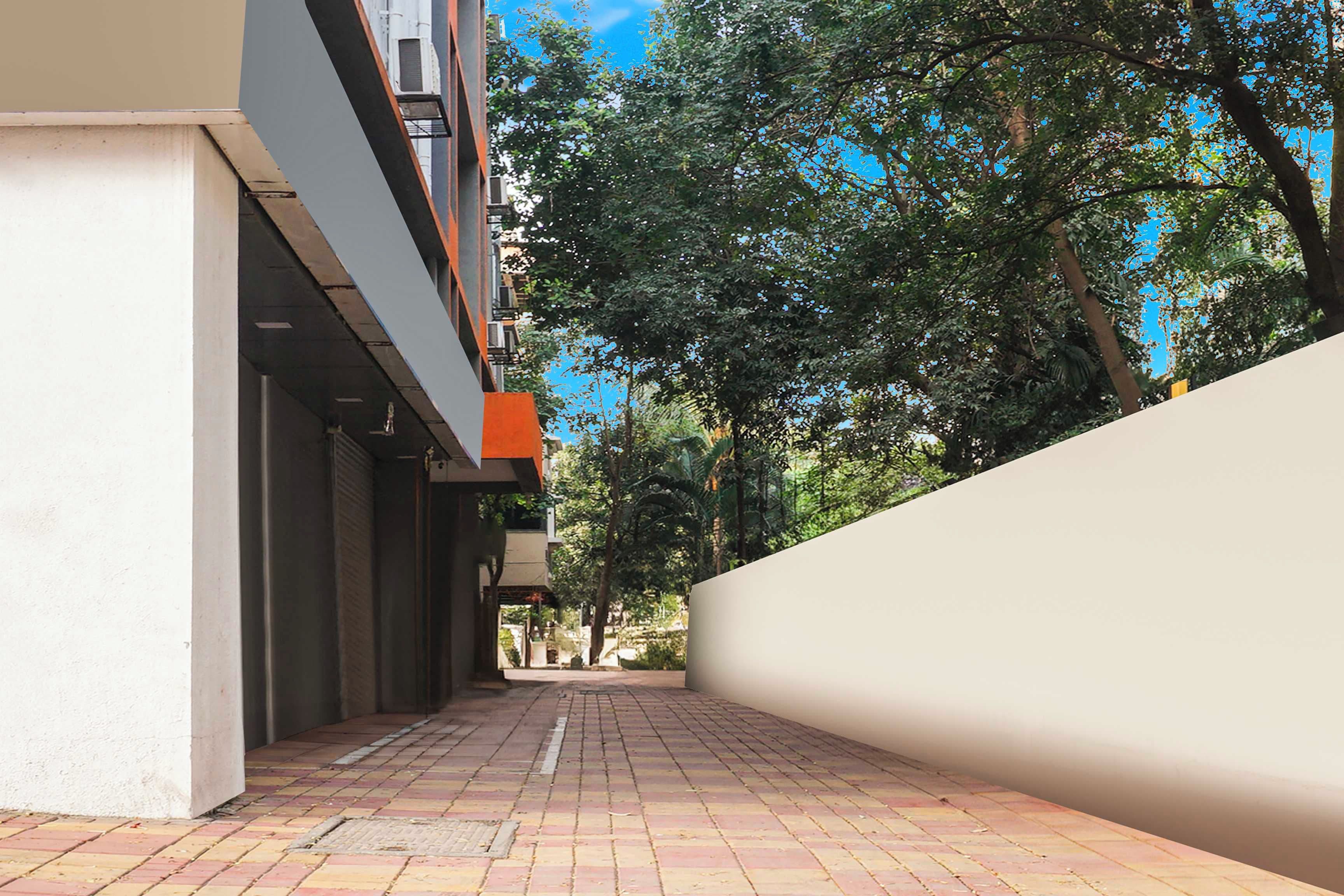 A narrow alleyway with a brick pavement, bordered by a white wall on one side and a building on the other.