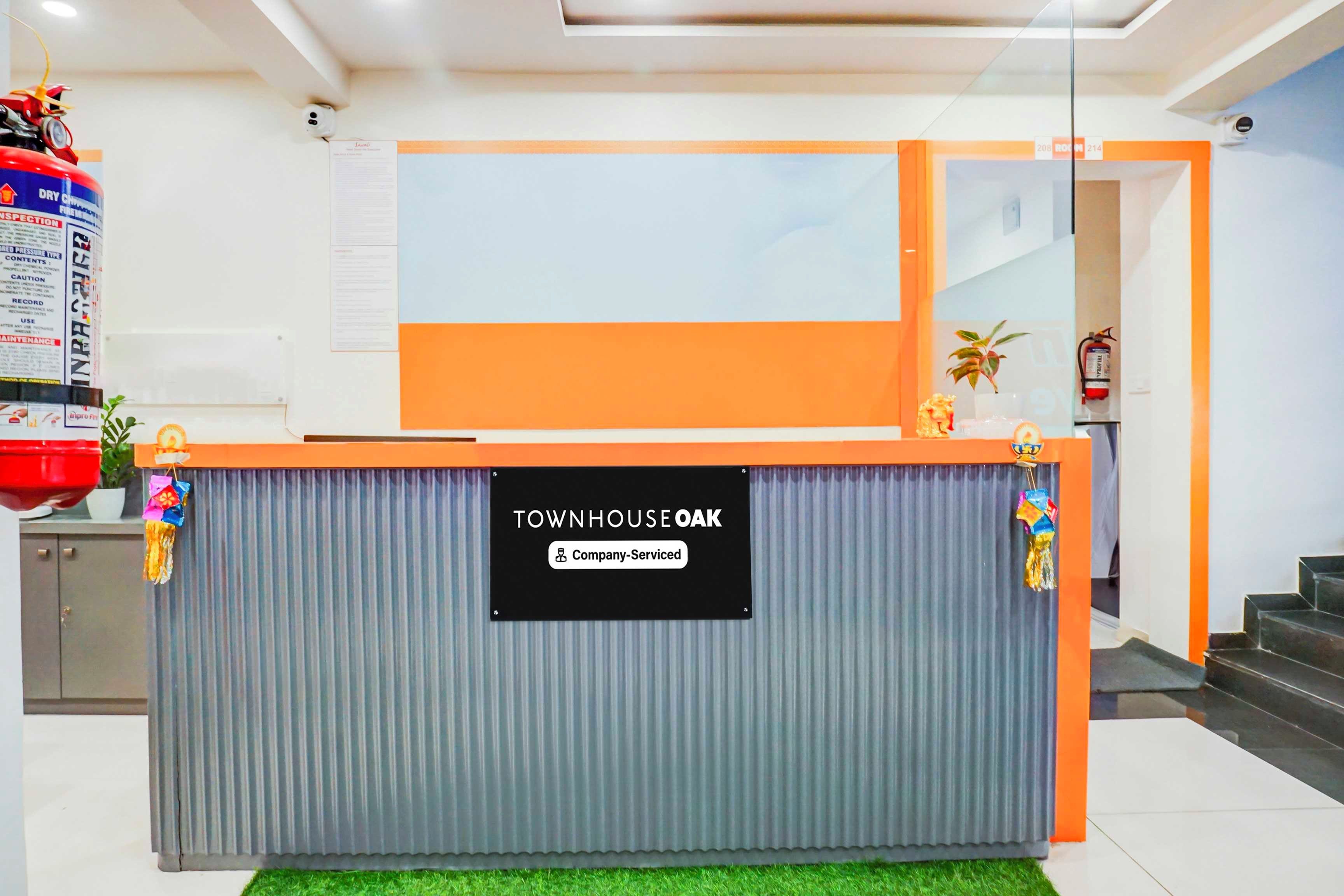 A reception desk with a sign reading 'TOWNHOUSE OAK Company-Serviced'.