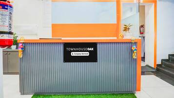A reception desk with a sign reading 'TOWNHOUSE OAK Company-Serviced'.