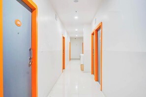 A corridor with doors on both sides, each marked with a number. - Townhouse Oak Hadapsar Sahyadri Hospital (Pune)