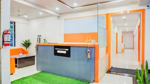 Zona de recepción con un mostrador azul y naranja, un extintor y un cartel que indica servicio de la empresa.