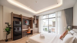 Quarto de hotel moderno com cama, escrivaninha, televisão e varanda com vista.