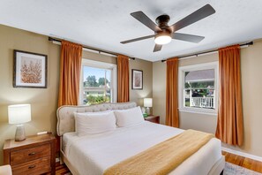A bedroom with a bed, nightstands, a ceiling fan, and two windows with curtains. - Hot Tub Hideaway - Firepit - Big Families (Loveland)