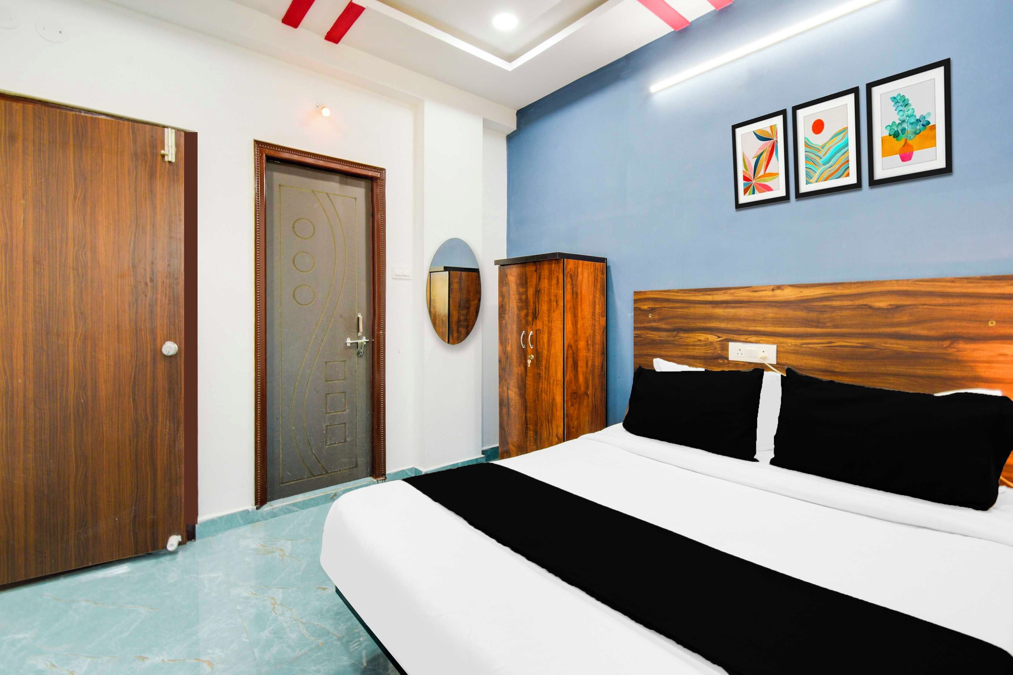 Quarto de hotel com cama, guarda-roupa, porta e obras de arte na parede.