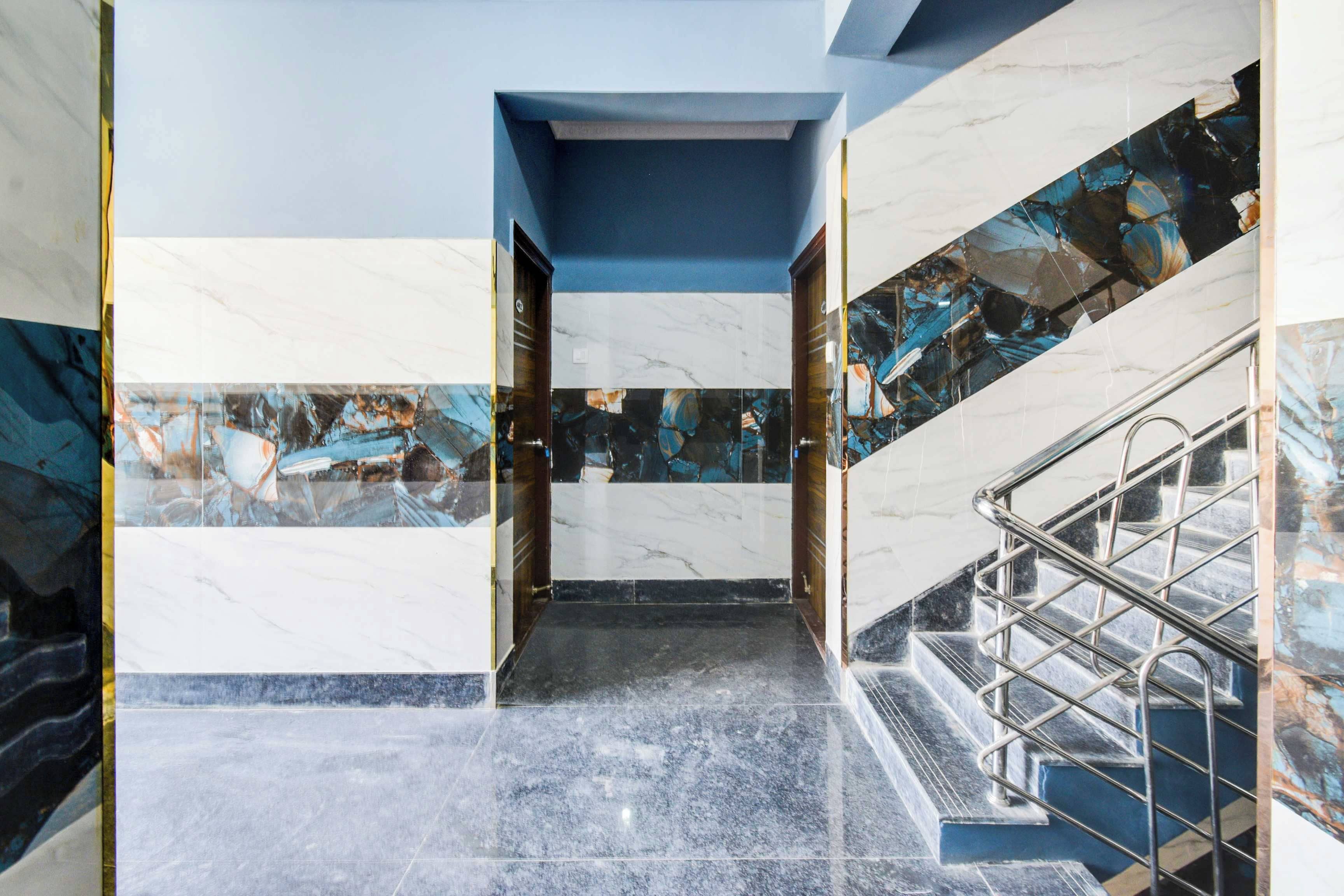 Una escalera de mármol con barandillas de metal que lleva a una puerta.