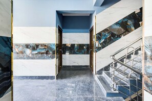 A marble staircase with metal railings leading to a door. - Townhouse Oak Ardha Nareeshwar Temple (Hyderabad)