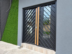 A modern building with a large window featuring a geometric pattern and a wooden accent.